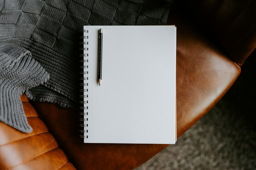 Open book with a quill pen resting on blank pages